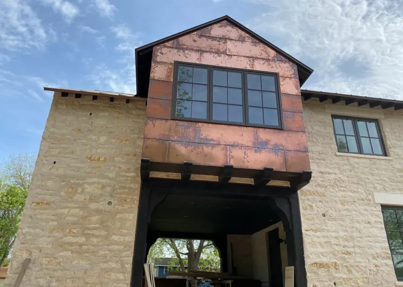 Copper metal panel facade on a stone building for Roof Repair in Sharon