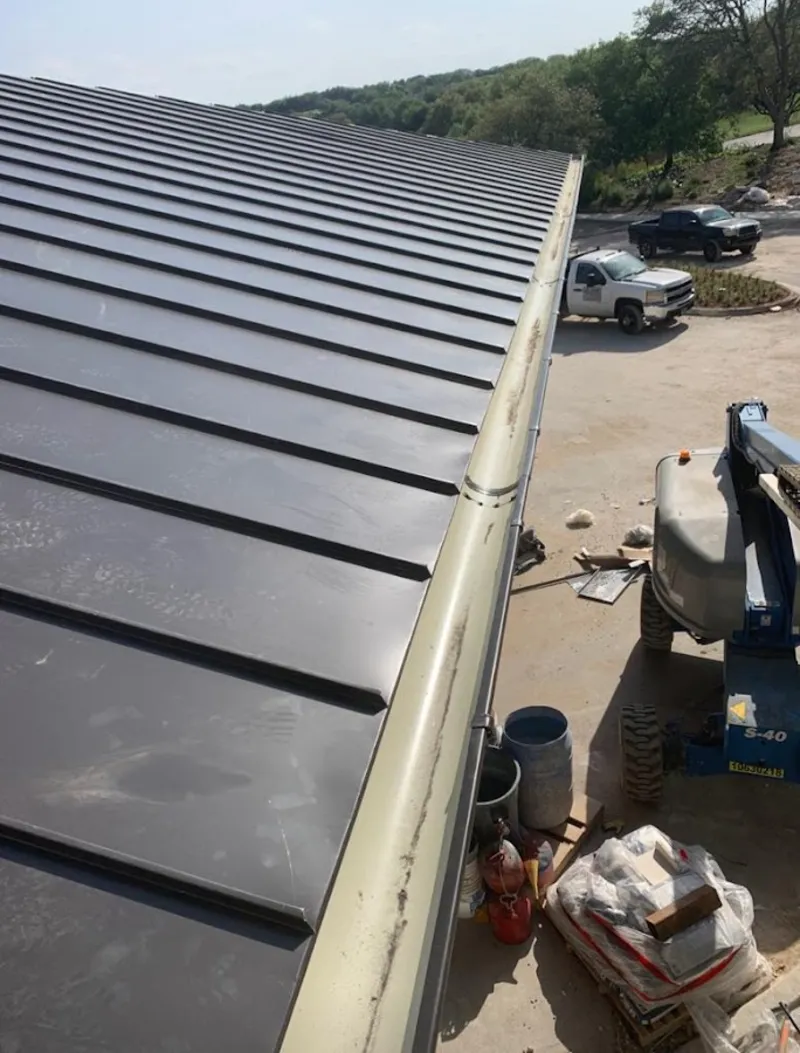Standing seam panel and gutter detail on a metal roofing jobsite in Sharon